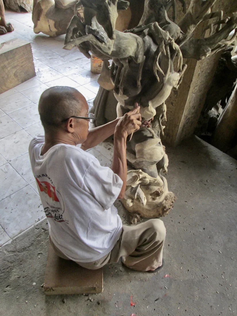 Pengrajin mengerjakan ukiran kayu di Ubud, Gianyar